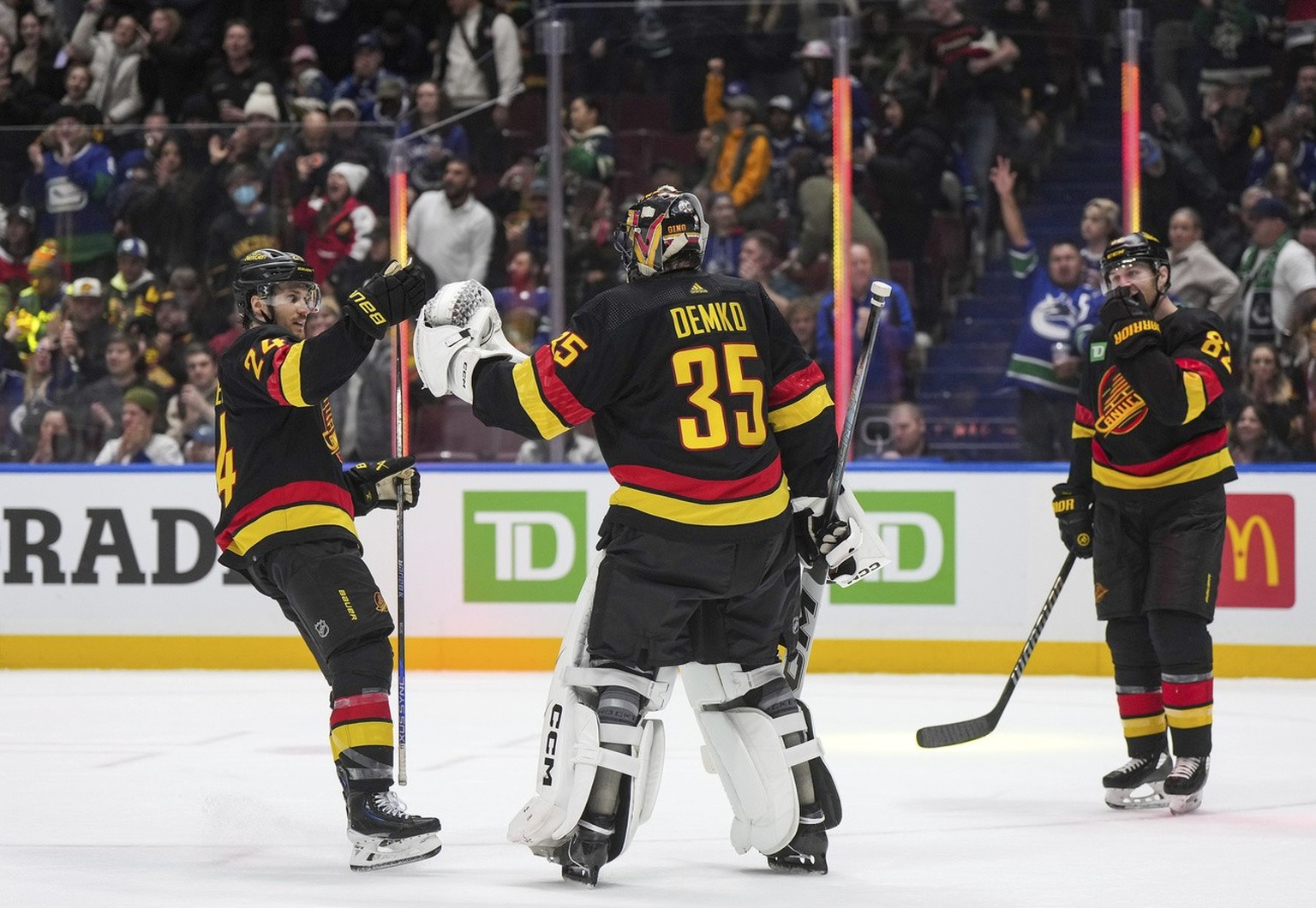 Vancouver Canucks&#039; Pius Suter, left, and goalie Thatcher Demko (35) celebrate as Ian Cole, right, watches after Vancouver defeated the Chicago Blackhawks during an NHL hockey game, in Vancouver,  ...