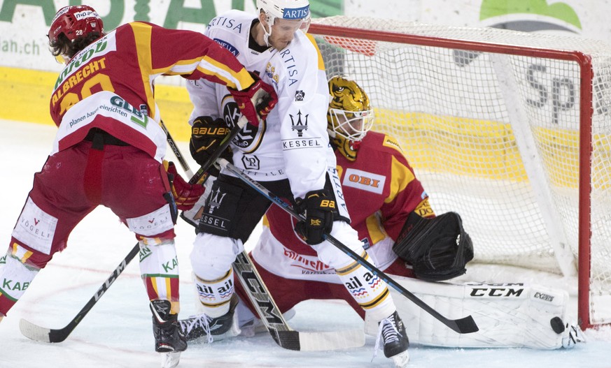 Langnaus Yannick-Lennart Albrecht, links, und Goalie Damiano Ciaccio, rechts, kaempfen um den Puck gegen Luganos Jani Lajunen, Mitte, waehrend dem Meisterschaftsspiel der National League zwischen den  ...