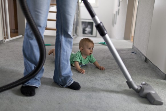 ZUR HEUTIGEN EIDGENOESSISCHEN ABSTIMMUNG UEBER DIE FAMILIENINITIATIVE DER SVP STELLEN WIR IHNEN AM SONNTAG, 24. NOVEMBER 2013 FOLGENDES THEMENBILD ZUR VERFUEGUNG - A mother hoovers the carpet while he ...