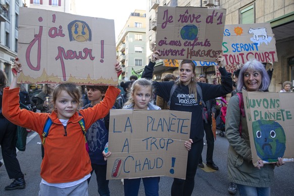 People holding placards attends a Global Climate Strike demonstration during the international strike day of Fridays For Future, in Geneva, Switzerland, Friday, October 22, 2021. Global Climate Strike ...