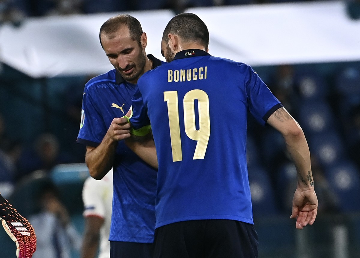 Italy's Giorgio Chiellini, left, gives the captain's armband to teammate Leonardo Bonucci before leaving the pitch during the Euro 2020 soccer championship group A match between Italy and Sw ...