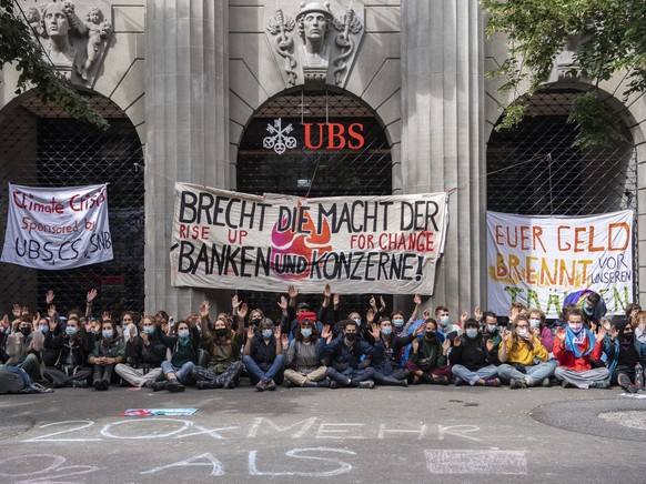 Menschen der Gruppierung von "Rise Up for Change" sitzen vor der UBS unter dem Motto "Transparenz aller Finanzfluesse" an der Bahnhofstrasse, aufgenommen am Montag, 2. August 2021  ...
