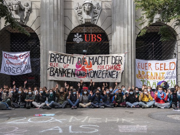 Menschen der Gruppierung von &quot;Rise Up for Change&quot; sitzen vor der UBS unter dem Motto &quot;Transparenz aller Finanzfluesse&quot; an der Bahnhofstrasse, aufgenommen am Montag, 2. August 2021  ...