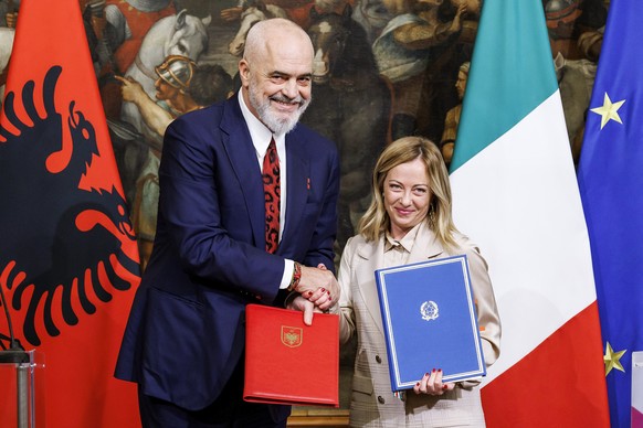 FILE – Italian Prime Minister Giorgia Meloni (right) and Albanian Prime Minister Edi Rama (left) shake hands after signing a memorandum of understanding on migrant management centers during…