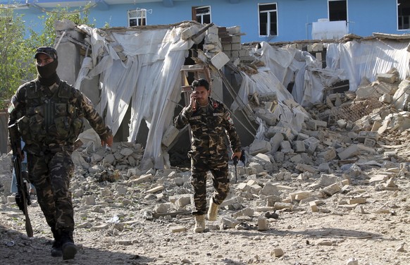 Security forces inspect an explosion site in Lashkar Gah, capital of southern Helmand province, Afghanistan, Saturday, Feb. 24, 2018. In a second suicide bombing attack near another military base in H ...