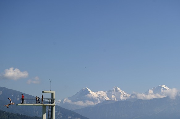 Badegaeste geniessen einen Altweibersommertag mit Blick auf Eiger, Moench und Jungfrau am Sonntag 19. September 2010 in Thun. (KEYSTONE/Peter Schneider)