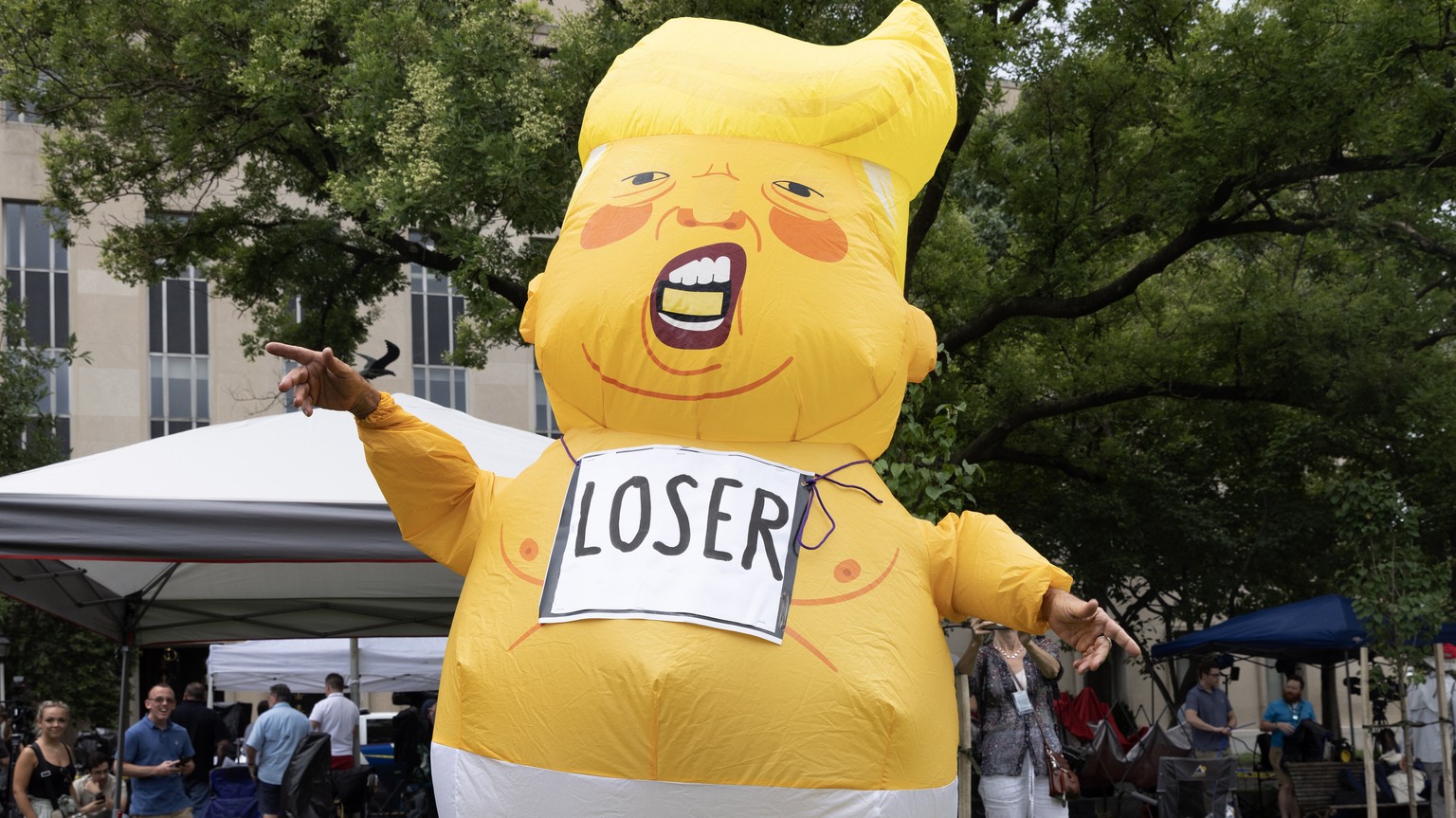 epa10783634 A protester wearing an inflatable costume stands outside the E. Barrett Prettyman United States Courthouse, where Judge Tanya Sue Chutkan will arraign former US President Donald J. Trump i ...