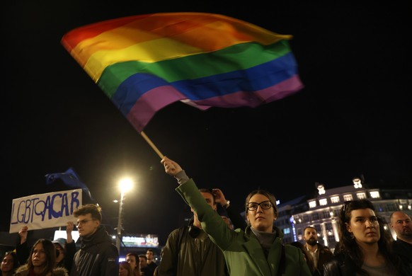 epa11202632 An LGBTQ+ activist waves a rainbow flag during a rally against police brutality against LGBTQ+ people in Belgrade, Serbia, 06 March 2024. LGBTQ+ activists protested against alleged police  ...