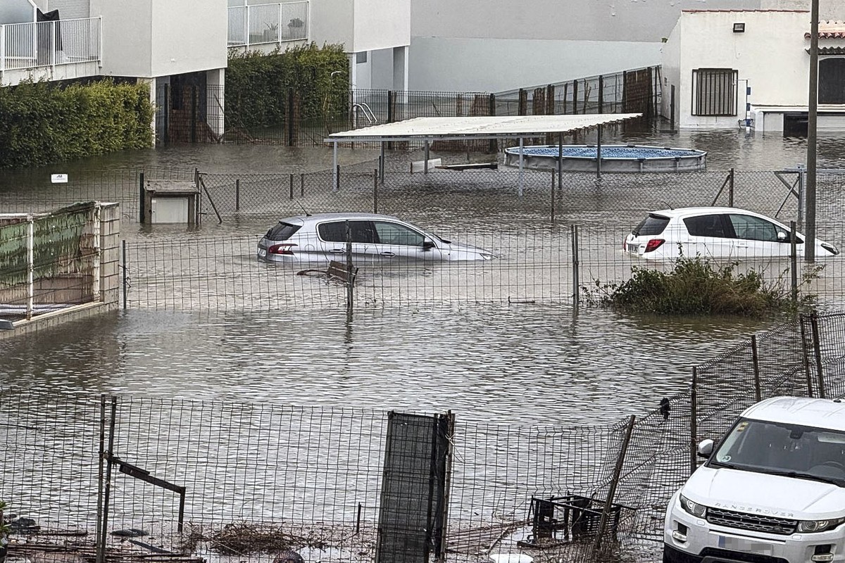 epa13315149 Cars are partially submerged along a flooded street near Terranova Beach in Oliva, Valencia province, Spain, 19 October 2026. Spain's national meteorological agency (AEMET) issued red ...