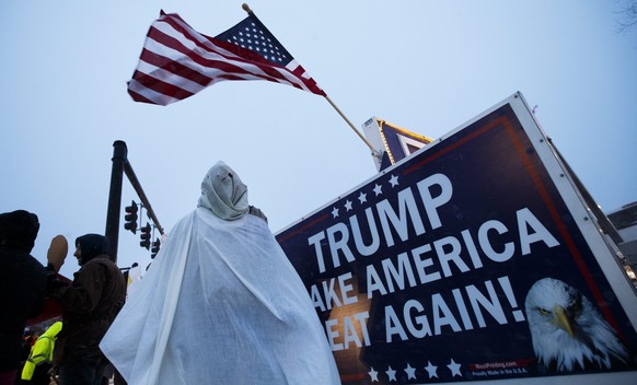 epa05150532 A protestor in an outfit resembling a uniform of the Ku Klux Klan (KKK) stands outside the site of a rally by US Republican presidential candidate Donald Trump (unseen) at the Verizon Wire ...