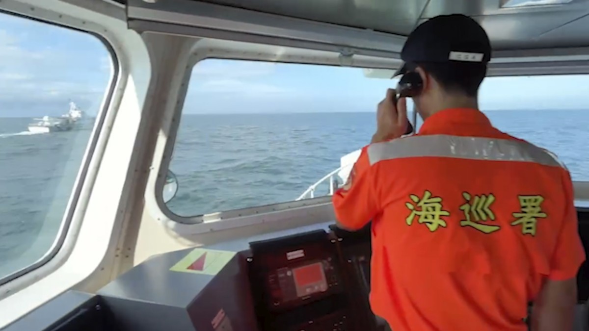 In this image from a video released by Taiwan Coast Guard Administration, a Taiwanese Coast Guard Administration member calls out on the megaphone for a Chinese Coast Guard ship at left to leave from  ...