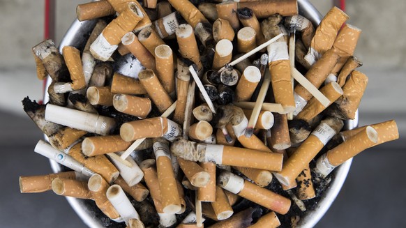 Zigaretten liegen in einem ueberfuellten Aschenbecher, am Donnerstag, 29. Maerz 2018 in Bern. (KEYSTONE/Peter Klaunzer)