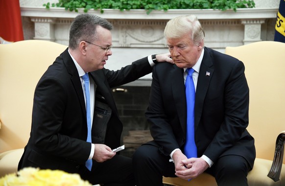 epa07091108 Pastor Andrew Brunson (L) prays for US President Donald J. Trump (R) during their meeting in the Oval Office of the White House in Washington, DC., USA, 13 October 2018. Pastor Andrew Brun ...