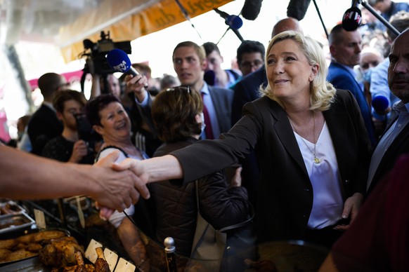French far-right leader Marine Le Pen, center, greets people as she campaigns in a market in Pertuis, southern France, Friday, April 15, 2022. (AP Photo/Daniel Cole)
Marine Le Pen