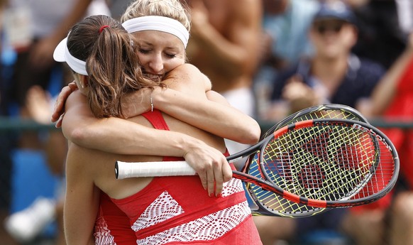 epa05465110 Timea Bacsinszky (back) and Martina Hingis of Switzerland celebrate after winning the women&#039;s second round doubles match against Bethanie Mattek-Sands and Coco Vandeweghe of USA of th ...