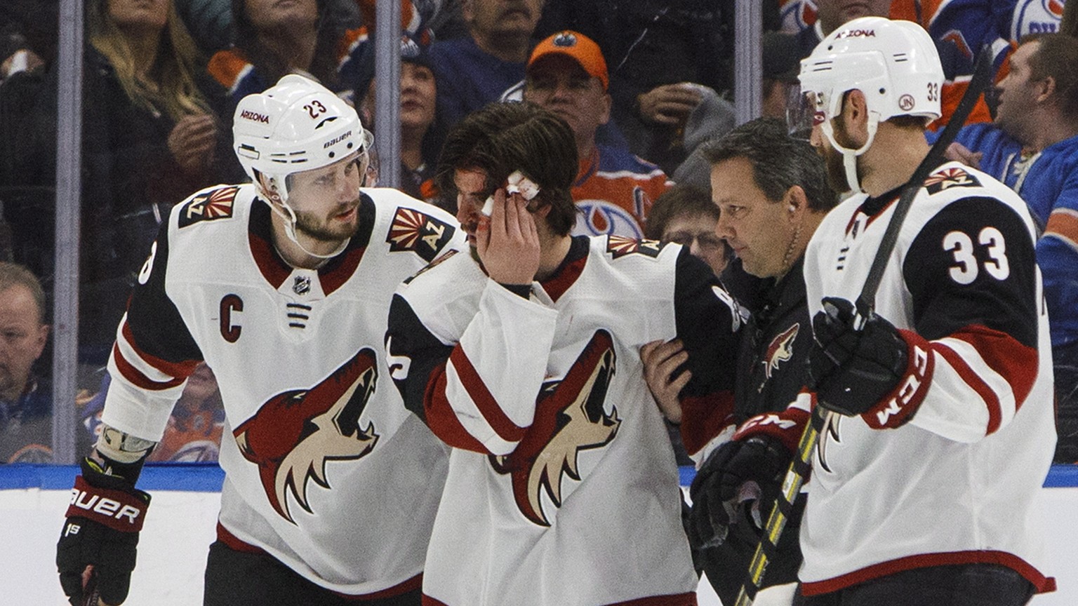 Arizona Coyotes&#039; Conor Garland (83) is helped off the ice after taking a puck to the head during the second period of an NHL hockey game against the Edmonton Oilers on Saturday, Jan. 12, 2019, in ...