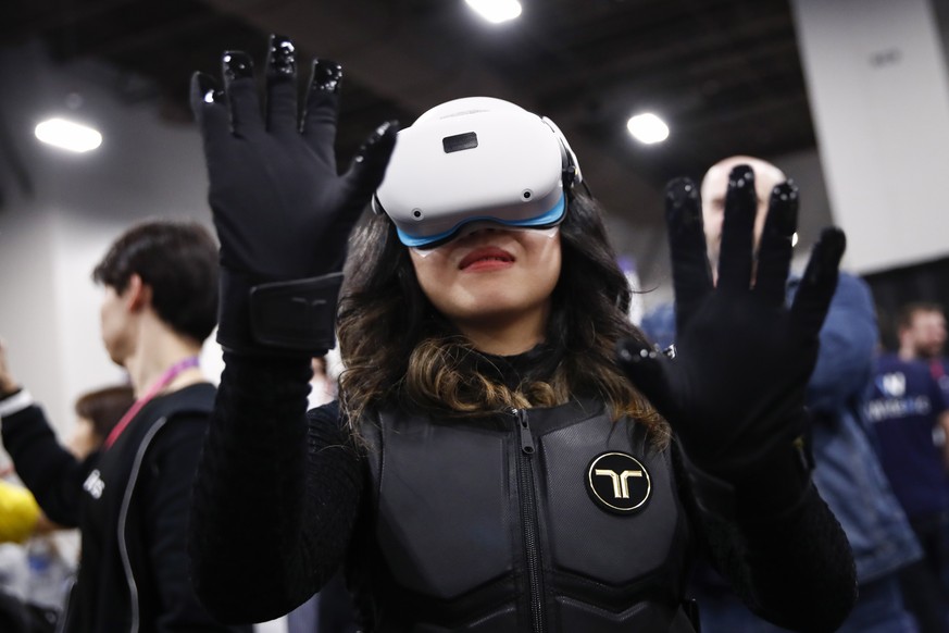 epaselect epa10388074 A person tries out bHaptic Inc.?s wireless haptic suit and gloves for VR/AR and gaming during the CES Unveiled Las Vegas at the 2023 International Consumer Electronics Show in La ...