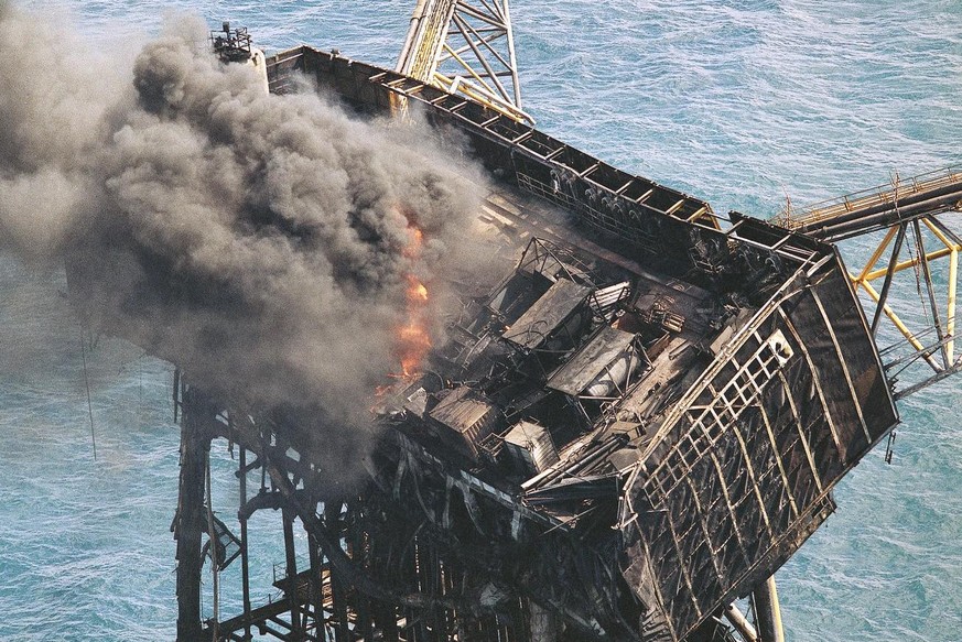 Thick smoke and flames still rise from the mangled remains of the Piper Alpha oil platform in the North Sea off the coast of Scotland in Aberdeen, July, 8, 1988. One-hundred-sixty oil workers were kil ...
