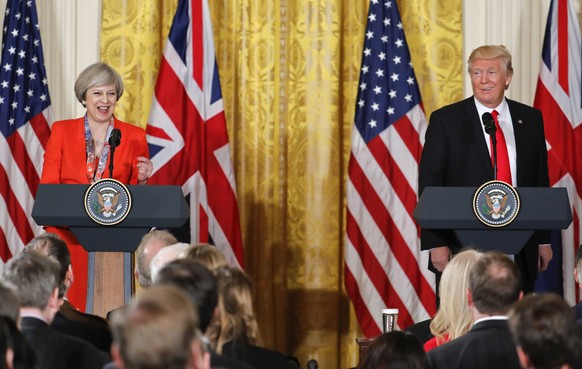 President Donald Trump and British Prime Minister Theresa May react to a question from a member of the media during their joint news conference in the East Room of the White House White House in Washi ...