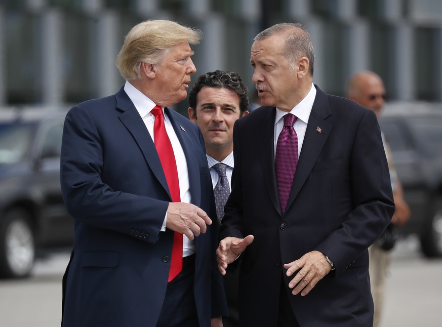 President Donald Trump, left, talks with Turkey&#039;s President Recep Tayyip Erdogan, right, as they arrive together for a family photo at a summit of heads of state and government at NATO headquarte ...