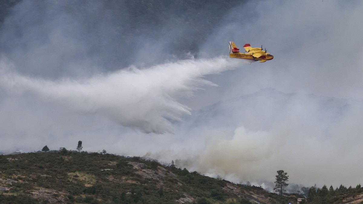 KEYPIX - epa13058028 A firefighting plane spreads water over a forest fire in As Fragas do Eume Natural Park in A Coruna, Galicia, northwestern Spain, 23 June 2026. The forest fire started in the vill ...