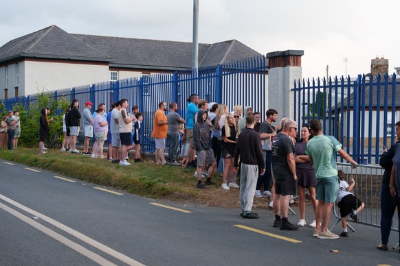 epa13158368 Onlookers gather outside Casement Aerodrome in Baldonnel, County Dublin, Ireland, 09 August 2026, following the extradition of alleged crime boss Daniel Kinahan from the United Arab Emirat ...