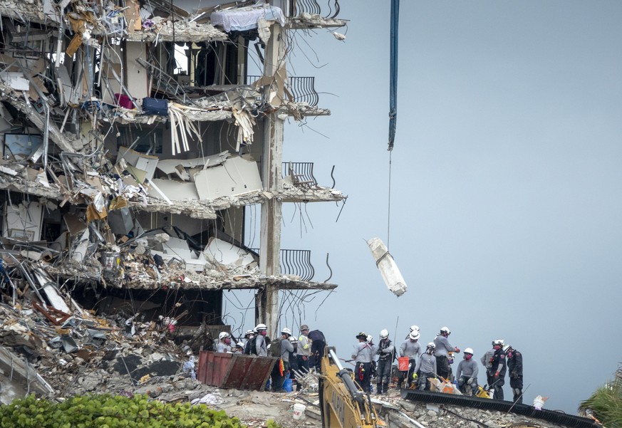 epa09313608 Rescue team search the partially collapsed Champlain Towers South condominium building in Surfside, Florida, USA, 30 June 2021. 12 people are confirmed dead and about 150 people remained u ...