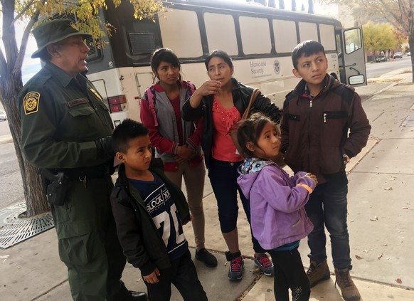 In this Thursday, Nov. 29, 2018 photo, a migrant family from Central America waits outside the Annunciation House shelter in El Paso, Texas, after a U.S. Immigration and Customs Enforcement officer dr ...