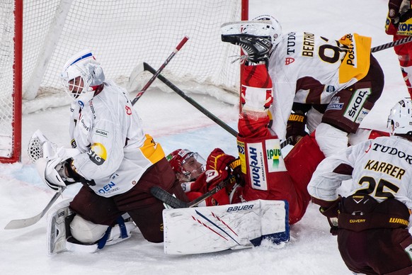Biels Mike Kuenzle, Mitte,im Duell mit Servettes Torhueter Sandro Zurkirchen, links, und Eliot Berthon im Eishockey Meisterschaftsspiel der National League zwischen dem EHC Biel und Genf Servette HC,  ...