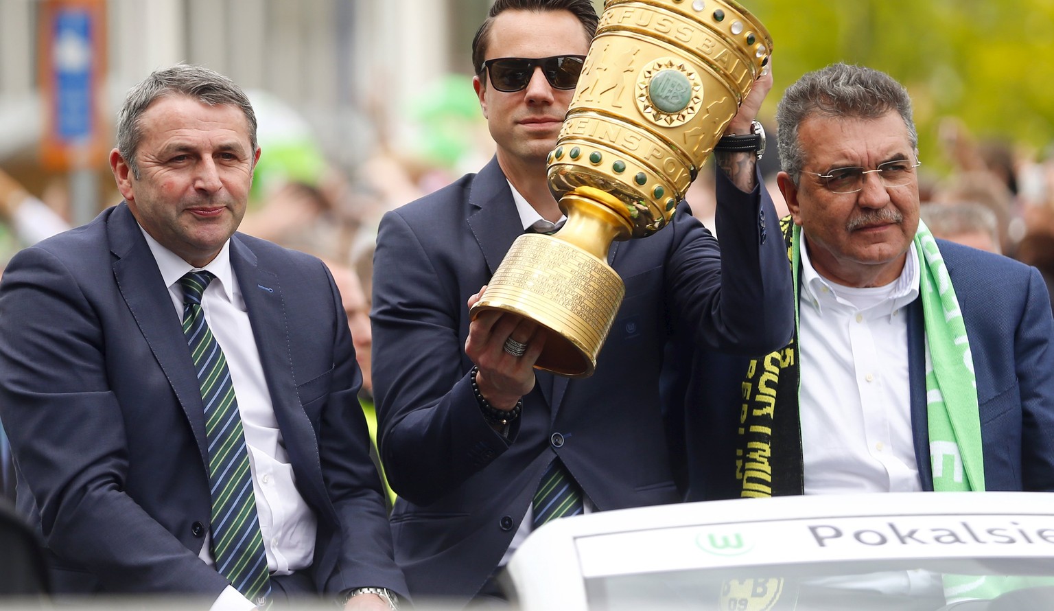 Benaglio lässt sich mit dem Pokal durch Wolfsburg chauffieren.