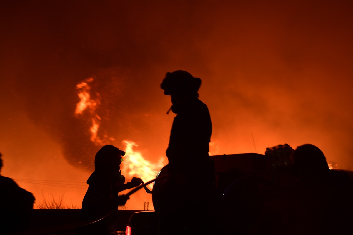 Firefighters try to extinguish a wildfire next to a highway in Afidnes area, northern Athens, Greece, Thursday, Aug. 5, 2021.Wildfires rekindled outside Athens and forced more evacuations around south ...