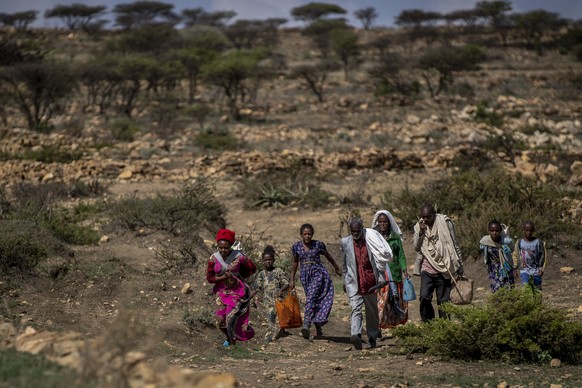 FILE - People walk from a rural area towards a nearby town where a food distribution operated by the Relief Society of Tigray was taking place, near the town of Agula, in the Tigray region of northern ...