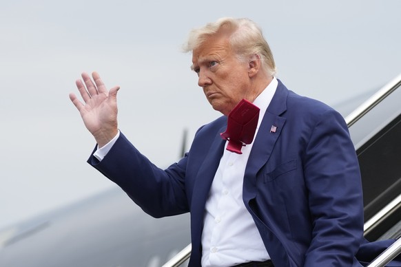 FILE - Former President Donald Trump waves as he steps off his plane at Ronald Reagan Washington National Airport, Aug. 3, 2023, in Arlington, Va. A slim majority of Americans approve of the U.S. Just ...