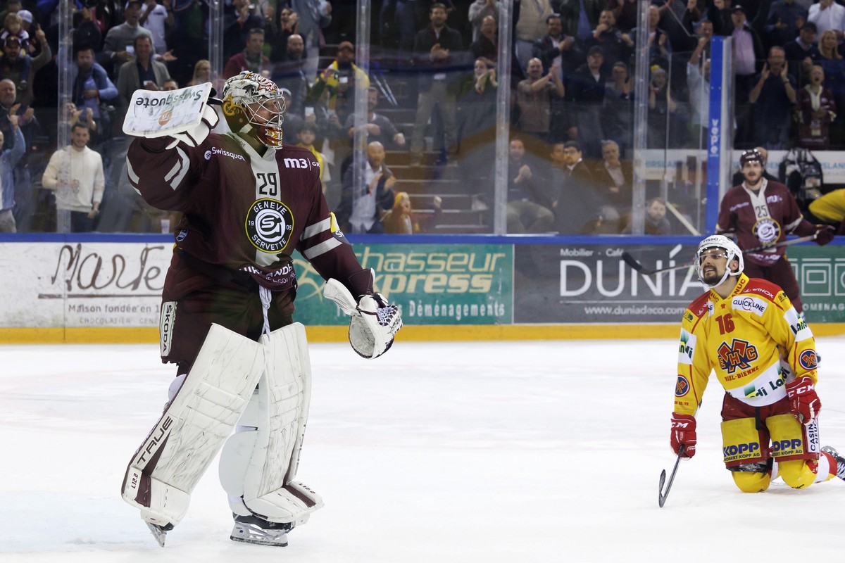 Geneve-Servette's goaltender Robert Mayer, left, reacts past Biel's forward Fabio Hofer, right, during the seventh and final leg of the ice hockey National League Swiss Championship final pl ...