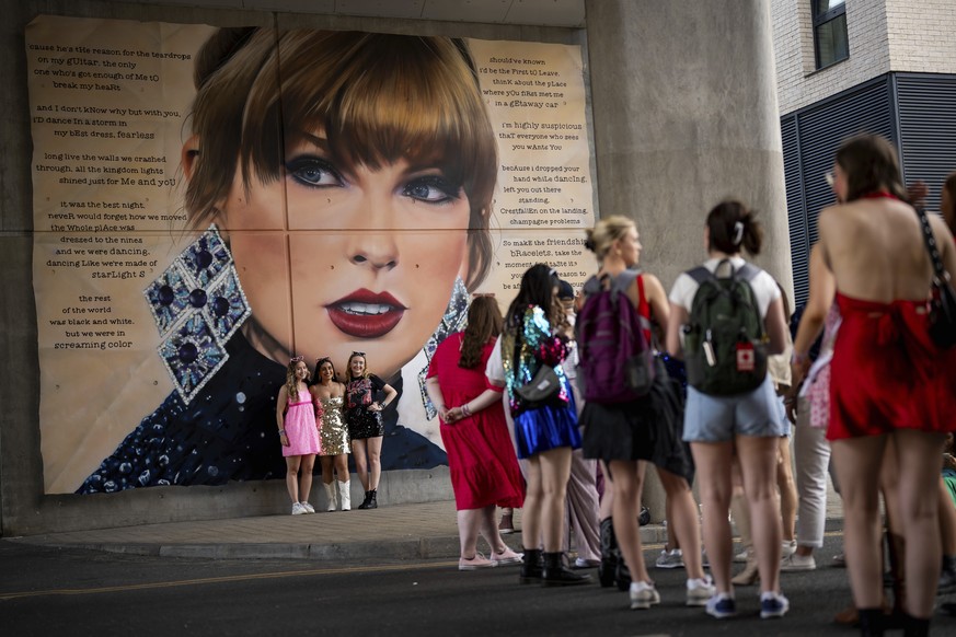 Taylor Swift fans pose for a photograph besides a mural, commissioned by London Mayor Sadiq Khan, before the first London concert of the Eras Tour on Friday, June 21, 2024 in London. (Photo by Scott A ...