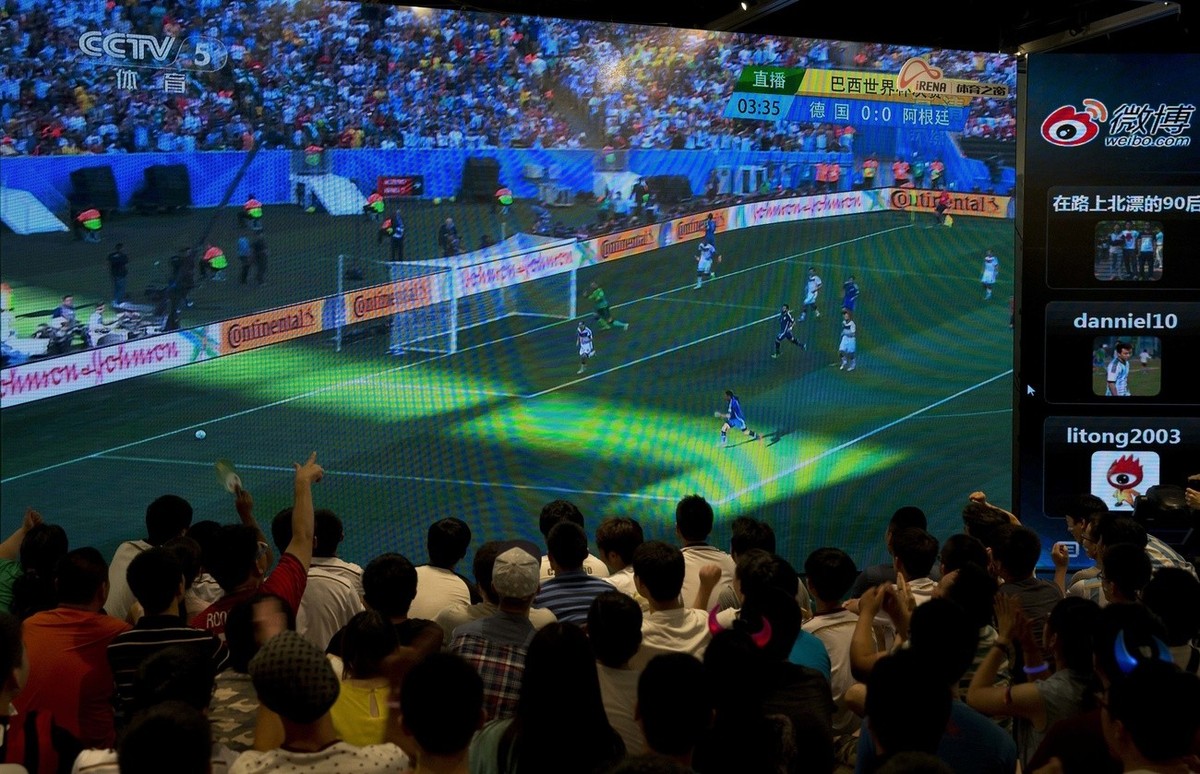 Chinese soccer fans watching the 2014 World Cup final match between Germany and Argentina, being played in Brazil, on a TV screen in Beijing, China Monday, July 14, 2014. (AP Photo/Andy Wong)
