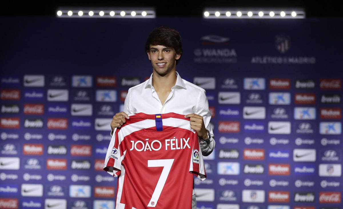 Atletico Madrid's new signing soccer player Joao Felix holds his new jersey as he poses for media during his official presentation at the Wanda Metropolitano Stadium in Madrid, Monday, July. 8, 2 ...