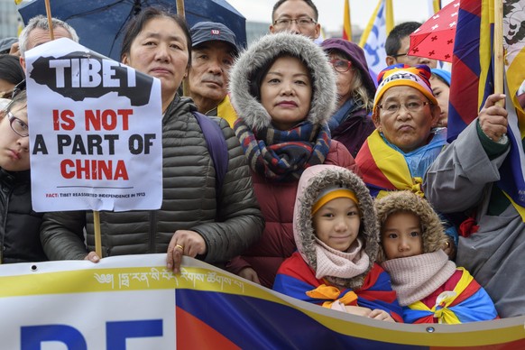 epa06593792 Tibetans living in Europe hold placards and Tibetan flags during a rally on the occasion of the 59th Aaniversary of the Tibetan Uprising Rally on the &#039;Place des Nations&#039; in front ...