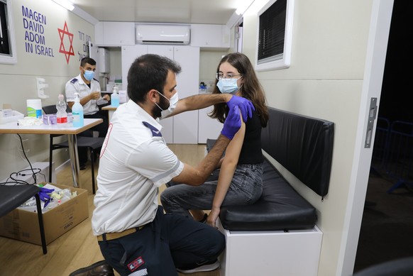 epa09324435 A minor receives a COVID-19 vaccine at a vaccination station in Tel Aviv, Israel, 05 July 2021. Israel starts a vaccination campaign to vaccinate minors between 12 to 18 years old. EPA/ABI ...