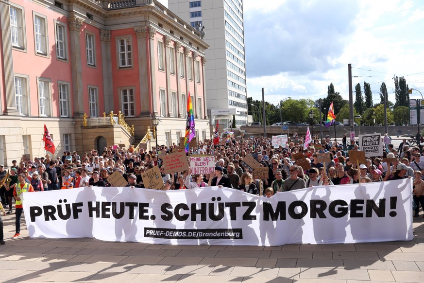 Demonstranten laufen mit Banner Pr�f heute. Sch�tz morgen um den Landtag w�hrend einer Demonstration f�r die �berpr�fung rechtsextremer Parteien durch das Bundesverfassungsgericht, Alter Markt, Potsda ...