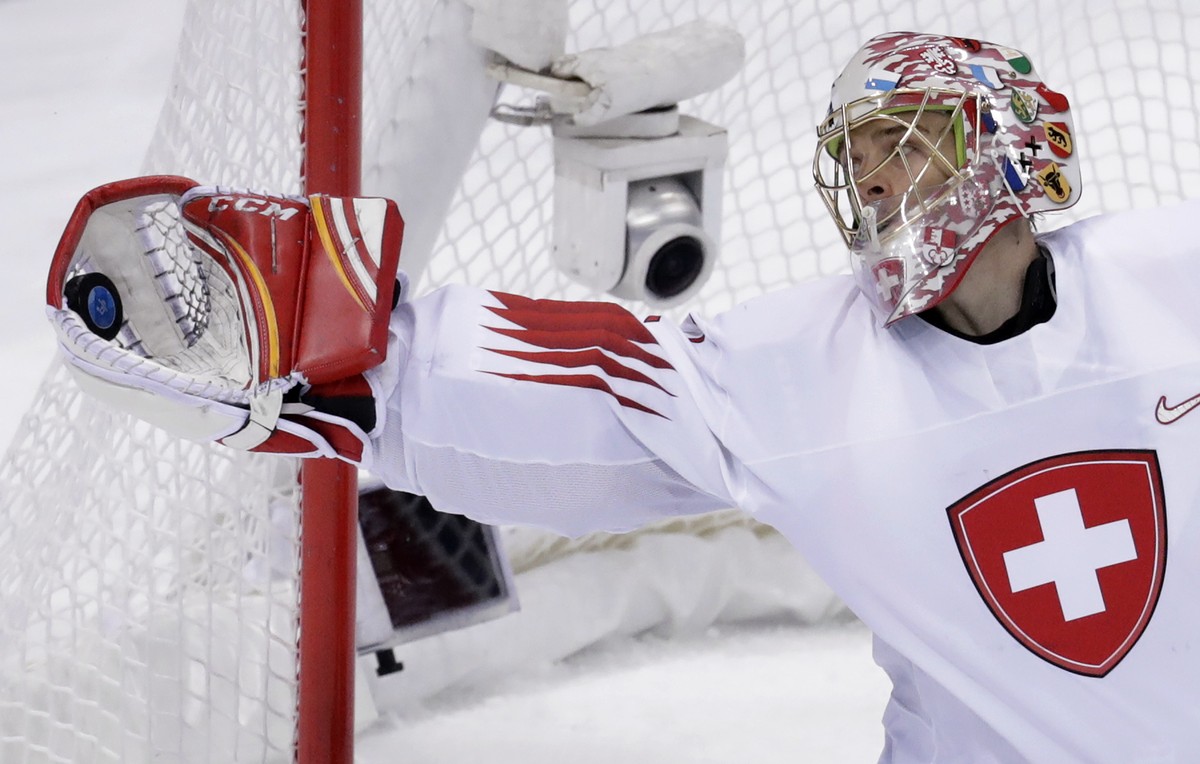 Goalie Jonas Hiller (1), of Switzerland, grabs the puck during the third period of the preliminary round of the men's hockey game against South Korea at the 2018 Winter Olympics in Gangneung, Sou ...