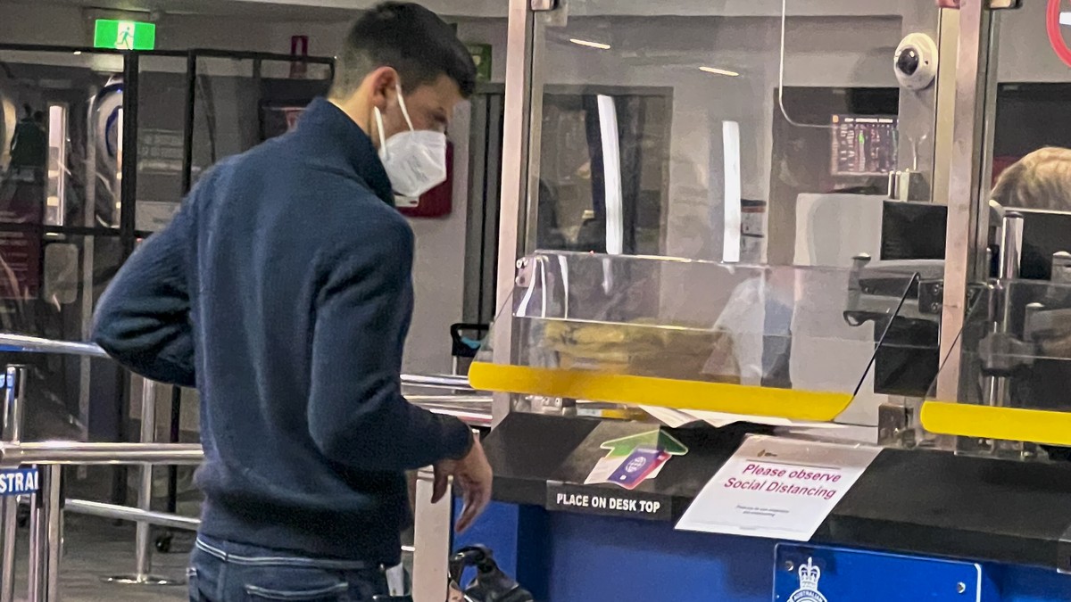 Australian Open defending champion, Serbia's Novak Djokovic waits at an Australian Border Force desk on his arrival at Melbourne Airport, Wednesday, Jan. 5, 2022. Locked in a dispute over his COV ...