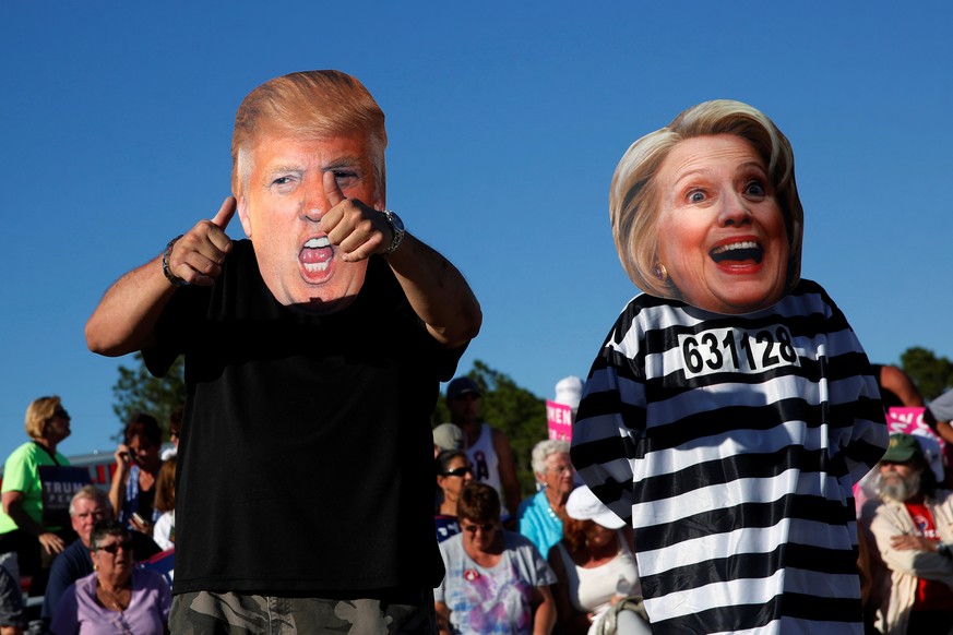 Craig Wendel dresses as Republican U.S. presidential nominee Donald Trump and his wife Jill Wendel wears a Hillary Clinton mask as they support Trump at a campaign rally in Naples, Florida, U.S. Octob ...