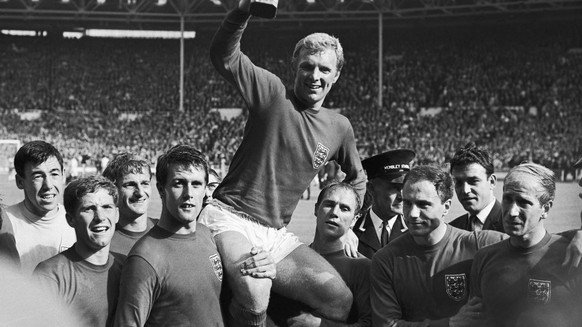 FILE - IIn this July 30, 1966 file photo England's soccer team captain Bobby Moore, is carried shoulder high by his teammates holding World Cup on July 30, 1966. England defeated West Germany 4-2 ...