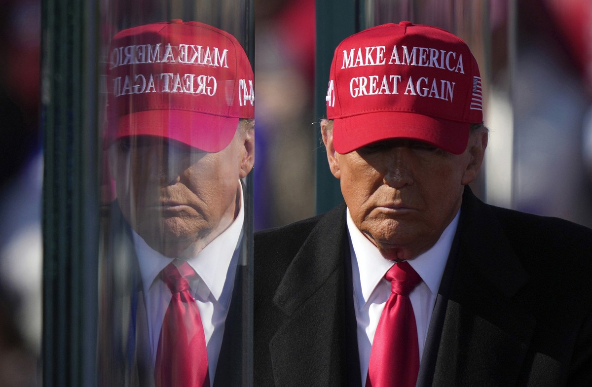 FILE - Republican presidential nominee former President Donald Trump is reflected in the bullet proof glass as he finishes speaking at a campaign rally in Lititz, Pa., Nov. 3, 2024. (AP Photo/Matt Rou ...