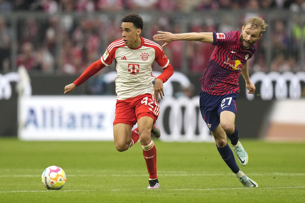 Bayern's Jamal Musiala, left, challenges for the ball with Leipzig's Konrad Laimer during the German Bundesliga soccer match between FC Bayern Munich and RB Leipzig at the Allianz Arena stad ...