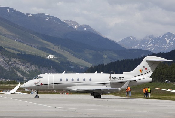 Ein Privatjet steht am Mittwoch, 24. Juni 2009, auf dem Flugplatz Samedan im Oberengadin derweil im Hintergrund ein Privatjet abhebt. (KEYSTONE/Arno Balzarini)