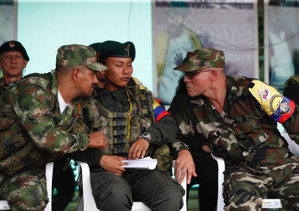 epa10576179 General Commander of the FARC dissidents, alias 'Ivan Mordisco' (R) speaks with other commanders during a meeting at Casa Roja, department of Caqueta, Colombia, 16 April 2023. Ne ...