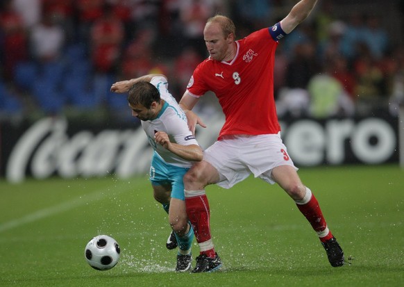 epa01377647 Turkish Goekdeniz Karadeniz (L) vies with Swiss Ludovic Magnin (R) during the EURO 2008 preliminary round group A match between Switzerland and Turkey at the St. Jakob Park stadium, Basel  ...