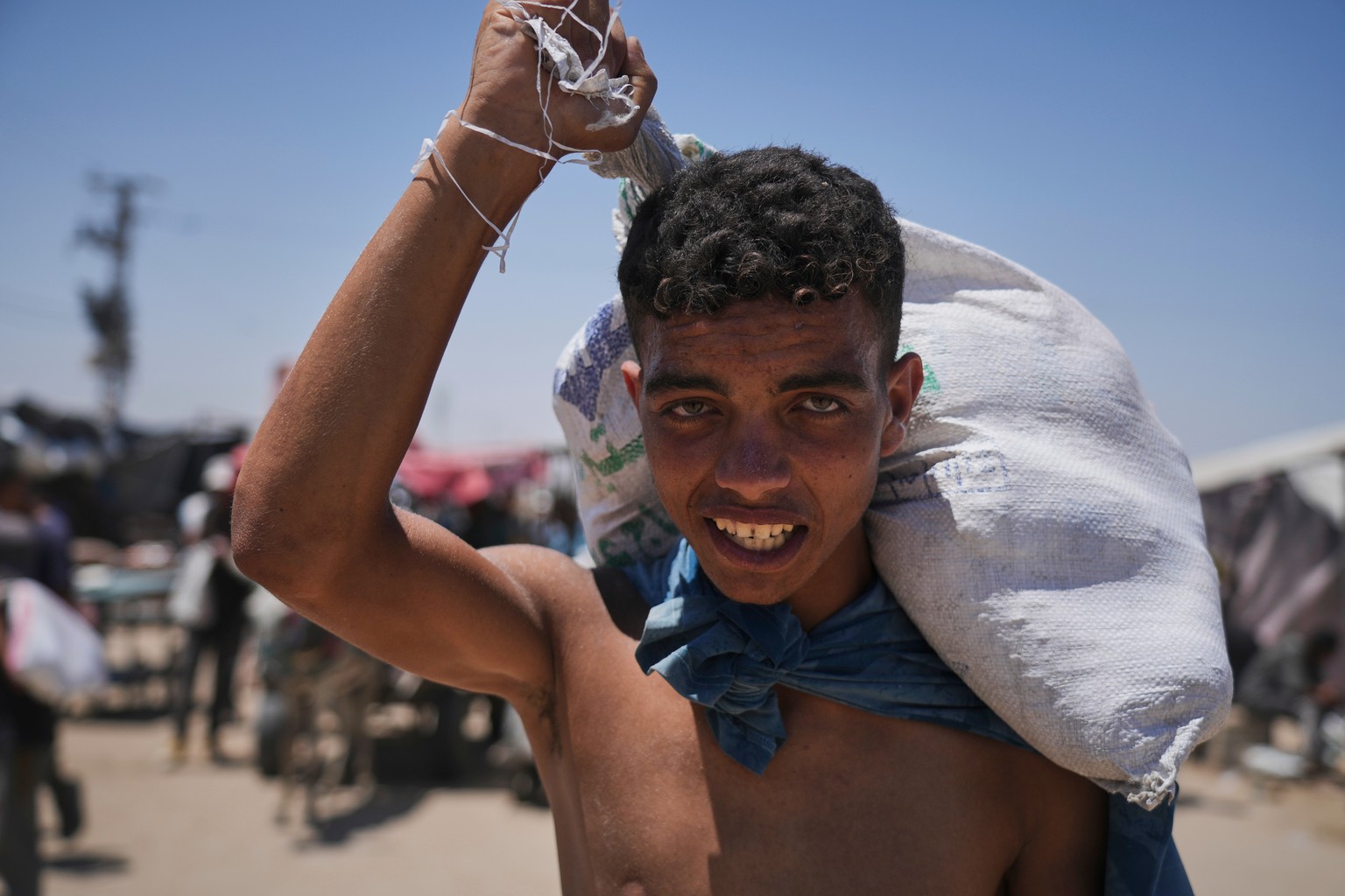 Palestinians carry food and humanitarian aid packages delivered by the Gaza Humanitarian Foundation, a U.S.-backed organization, in Rafah, southern Gaza Strip, Thursday, June 26, 2025. (AP Photo/Abdel ...